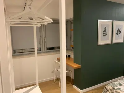 a bedroom with a green wall and a desk in a room at Palace House Apartment in Porto