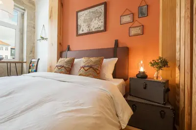 a bedroom with an orange wall with a bed at São Vítor Douro Living in Porto