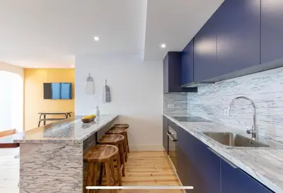a kitchen with blue cabinets and a sink and stools at São Vítor Douro Living in Porto