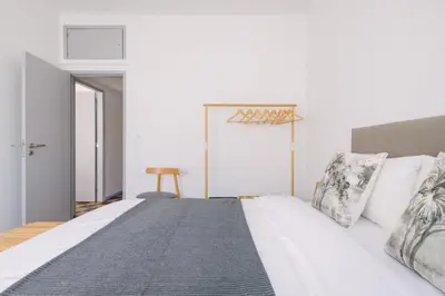 a bedroom with a large bed with white sheets and pillows at D&S - Family Apartments I in Porto