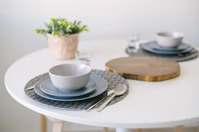 a white table with two plates and a cup and spoon at D&S - Family Apartments I in Porto