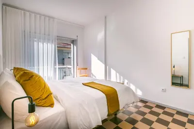 a bedroom with a bed with yellow pillows on it at D&S - Family Apartments I in Porto