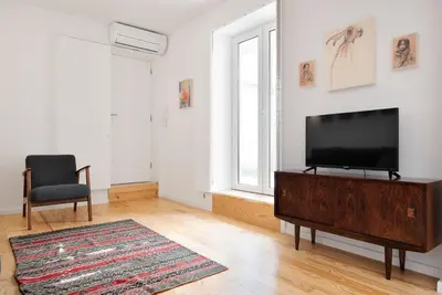 a living room with a flat screen tv and a chair at Oporto Classic Terrace in Porto