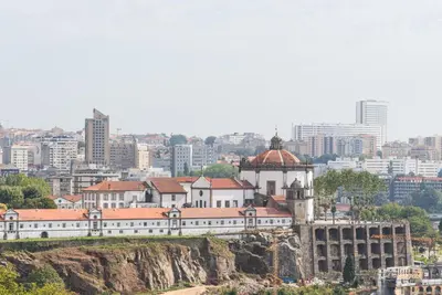 a building on a hill with a city in the background at GuestReady - Hemisphere Apt in Porto