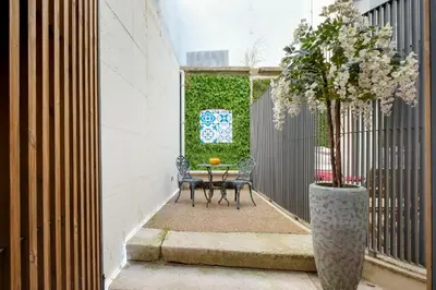 a patio with a table and a tree in a vase at The Bitcoin Chapel Iconic Luxury Residence in Porto