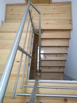 a staircase with a metal handrail and wooden stairs at PORTO RICO STUDIOS in Porto