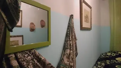 a mirror hanging on a wall next to a bed at AL-Almada-2 in Porto