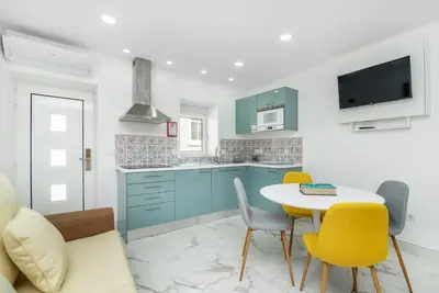 a kitchen with blue cabinets and a table and chairs at Maredimo Village Porto Casa 5 in Porto