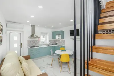 a kitchen and living room with a table and yellow chairs at Maredimo Village Porto Casa 5 in Porto