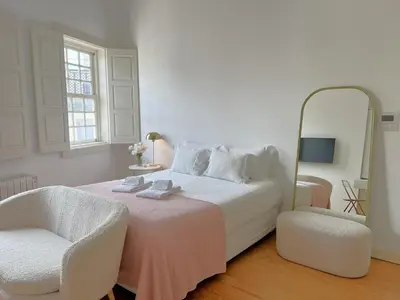 a living room with chairs and a tv on the wall at Aliados Downtown Studio by Porto City Hosts in Porto