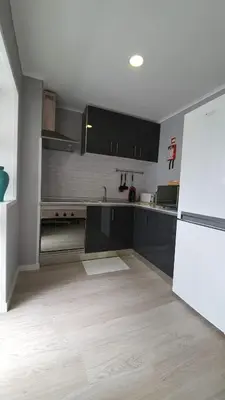 a kitchen with black cabinets and a white refrigerator at Gaiapart in Vila Nova de Gaia
