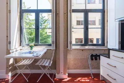 a kitchen with windows and a white table and chairs at ON Apartments - Center in Porto