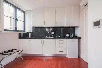 a kitchen with white cabinets and a wooden floor at ON Apartments - Center in Porto