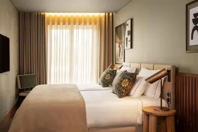a bedroom with a bed with pillows and a painting at Fontinha Porto, Trademark Collection by Wyndham in Porto