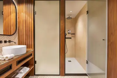 a bathroom with two sinks and a mirror at Fontinha Porto, Trademark Collection by Wyndham in Porto