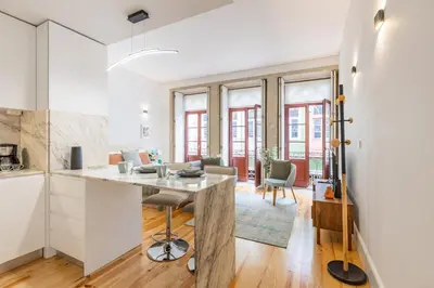 a white kitchen with a table and chairs at Sol Downtown Studio with Juliet Balcony in Porto