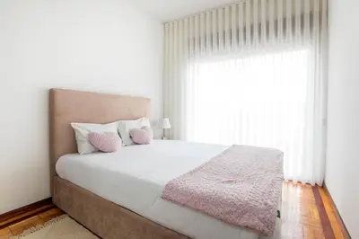 a bedroom with a large bed with a large window at Oporto Trindade Downtown in Porto