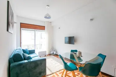 a bedroom with a large white bed with a wooden floor at Oporto Trindade Downtown in Porto