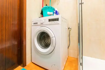 a washing machine in a bathroom with a shower at Oporto Trindade Downtown in Porto