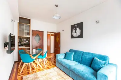 a living room with a blue couch and a glass table at Oporto Trindade Downtown in Porto