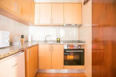 a kitchen with wooden cabinets and a sink at Oporto Trindade Downtown in Porto