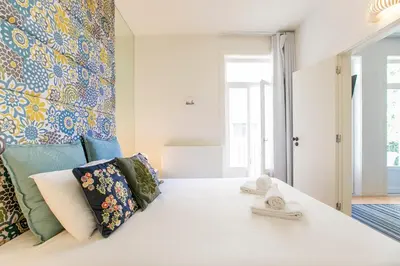 a bedroom with a large white bed with towels on it at Oporto Flores Plaza by LovelyStay in Porto
