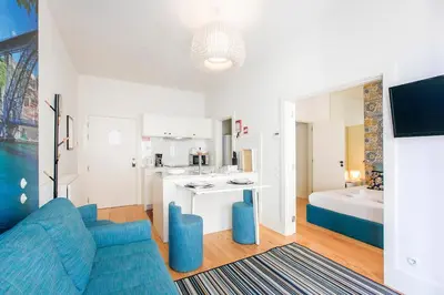 a living room with a blue couch and a kitchen at Oporto Flores Plaza by LovelyStay in Porto
