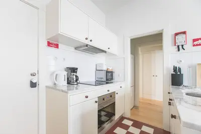 a kitchen with white cabinets and a counter top at Oporto Flores Plaza by LovelyStay in Porto