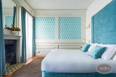 a bedroom with a large white bed and a fireplace at Casa Antiga in Porto