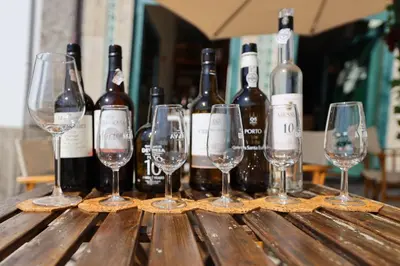 a group of wine bottles and glasses on a wooden table at FLH Porto Traditional Studio with Terrace in Porto