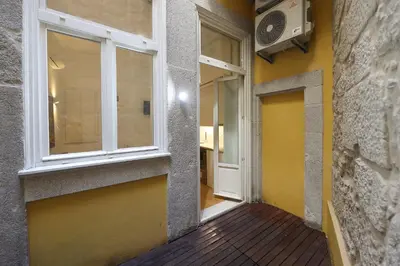 a hallway of a building with a window and a door at FLH Porto Traditional Studio with Terrace in Porto