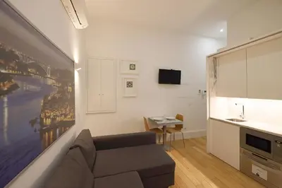a living room with a couch and a tv and a kitchen at FLH Porto Traditional Studio with Terrace in Porto