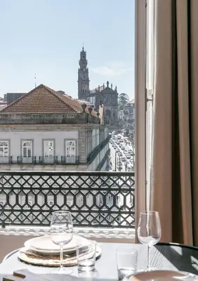 a table with two glasses and a view of a city at Oportments - S.Bento in Porto