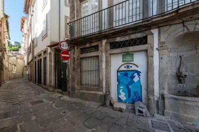 an alley with a blue door on the side of a building at Prime Riverside Duplex in Porto