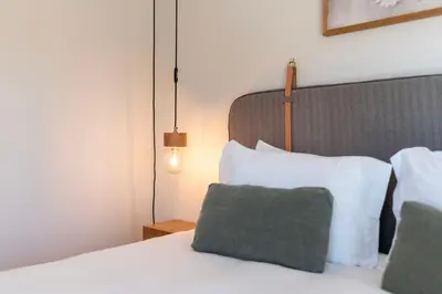a bedroom with a white bed with a green pillow at Prime Riverside Duplex in Porto