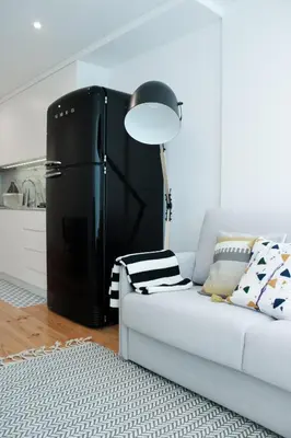 a refrigerator in a living room next to a couch at Oporto Garden's Home in Porto