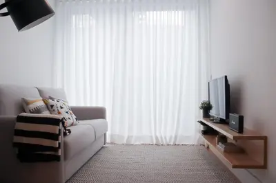 a living room with a couch and a television at Oporto Garden's Home in Porto