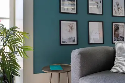 a living room with a blue wall with a chair and a table at Ribeira Old Town Charming Flat w/ AC by LovelyStay in Porto