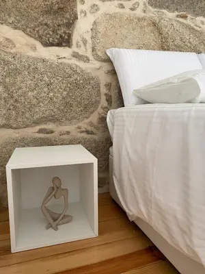 a nightstand with a statue on it next to a bed at My Little Porto - Charming house in Miragaia, Porto in Porto
