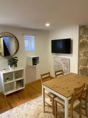 a dining room with a table and a tv on the wall at My Little Porto - Charming house in Miragaia, Porto in Porto