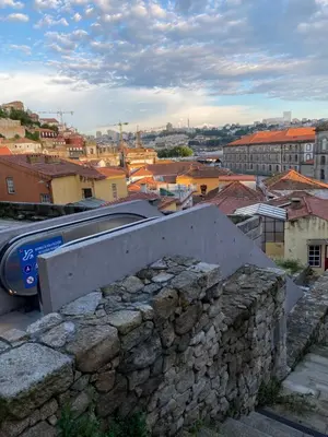a train traveling through a city with a stone wall at My Little Porto - Charming house in Miragaia, Porto in Porto