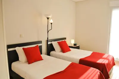 two beds in a room with red and white at Apartamentos Portodouro - Santa Catarina in Porto