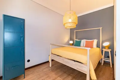 a bedroom with a bed and a blue door at Camões Loft in Porto