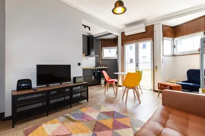 a living room with a television and chairs at Camões Loft in Porto