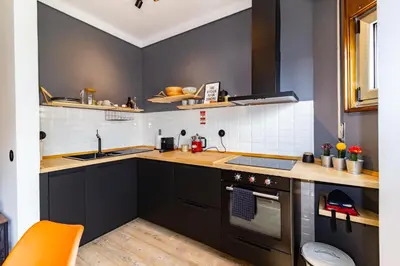 a small kitchen with black cabinets and a sink at Camões Loft in Porto