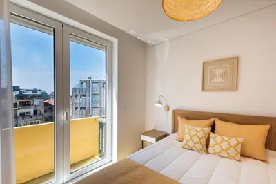 a bedroom with a bed and a large window at Casa das Musas 2 in Porto