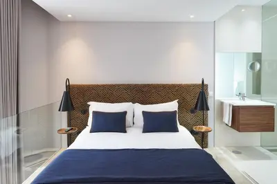 a bedroom with a large bed and a bathroom at Rio da Vila in Porto