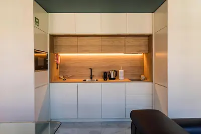 a kitchen with white cabinets and a sink at Infante Douro View in Porto