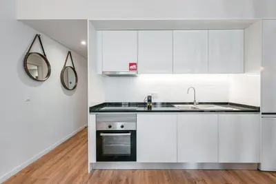 a kitchen with white cabinets and a sink at GuestReady - Nature-themed Studio in Porto
