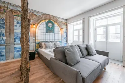 a living room with a couch in front of a wall at GuestReady - Nature-themed Studio in Porto